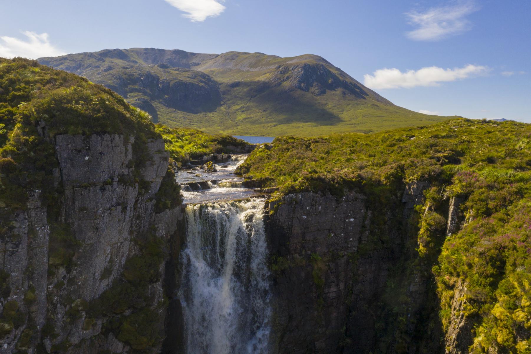 Drone Close-up of falls flowing into Allt Chrànaidh, flowing out of  Loch na Gainmhich (Gan-vig) - Glas Beinn (Background) Assynt, Sutherland
